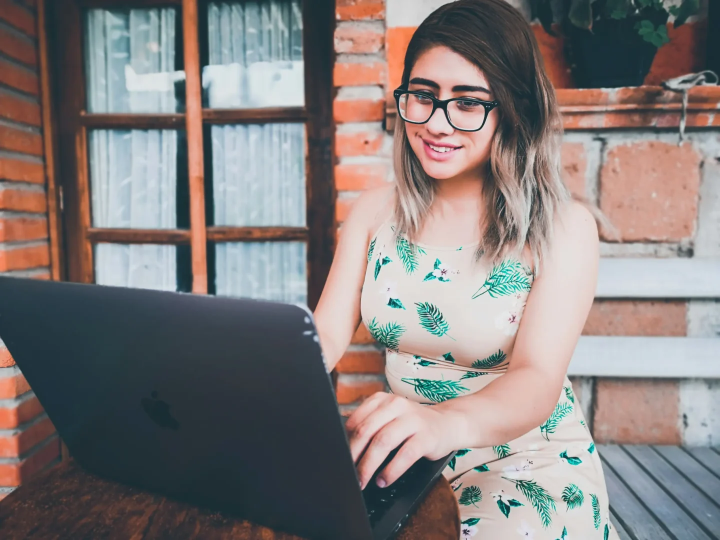 Smiling small business owner working on a laptop, researching how much a small business website costs.