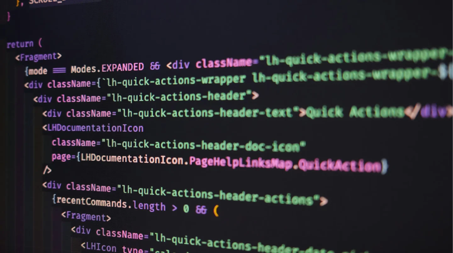 Close-up of front-end web development code on a dark screen showing HTML and JavaScript